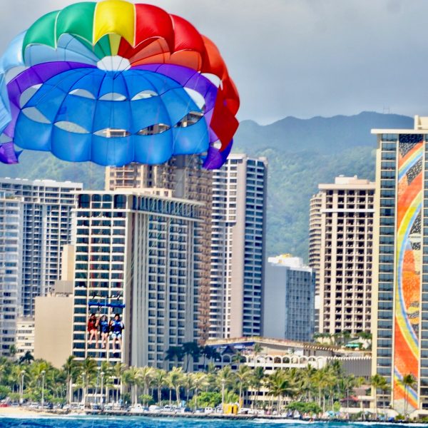 a parachute with a body of water with a city in the background