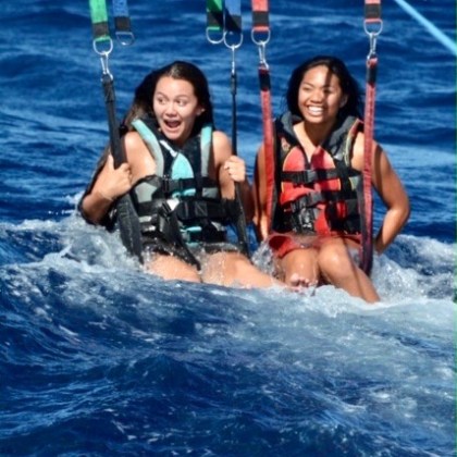 a group of people riding on the back of a boat in the water