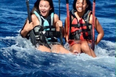 a group of people riding on the back of a boat in the water