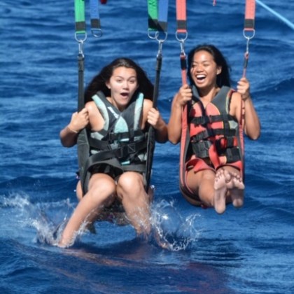 a group of people riding on the back of a boat in the water